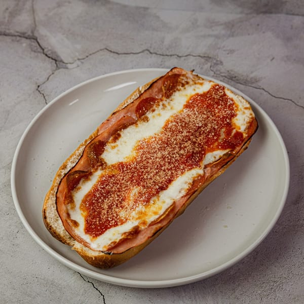A toasted All Star Pizza & Pasta sub with melted cheese, red sauce, and pepperoni on a white plate.
